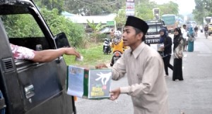 Aktifis Karang Taruna Madina menyodorkan kotak Koin Cinta Rizky kepada supir yang melintas di kawasan Dalan Lidang, Panyabungan