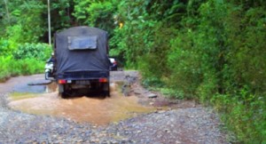 Satu truk berpaspasan dengan sepeda motor di jalur Jembatan Merah - Simpang Gambir yang hancur