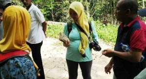 Seorang arkelog wanita dari Balai Arkeologi Medan meneliti material candi di Aek Milas Siabu