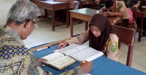 Seorang pelajar SMA Negeri 3 Panyabungan membaca Al-Qur'an di hadapan guru